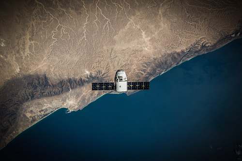 desktop wallpapers A space satellite hovering above the coastline space